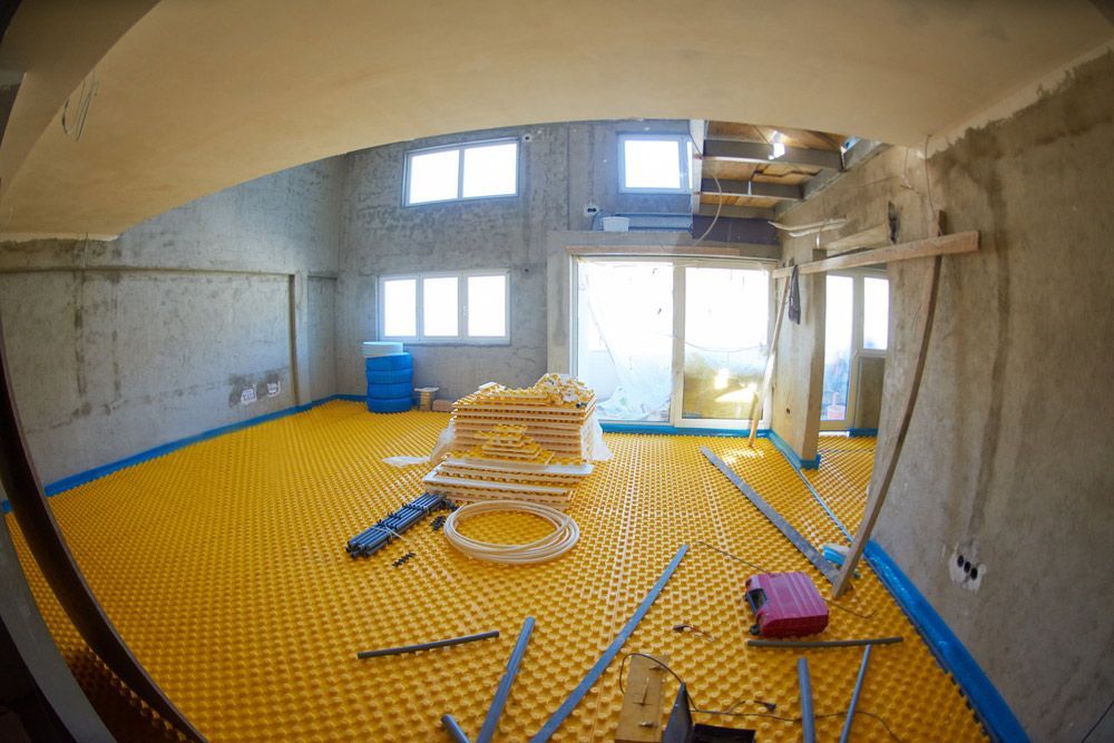Yellow Underfloor Heating Posed In A Under Construction Building — Sydney Underfloor Heating in Sydney, NSW