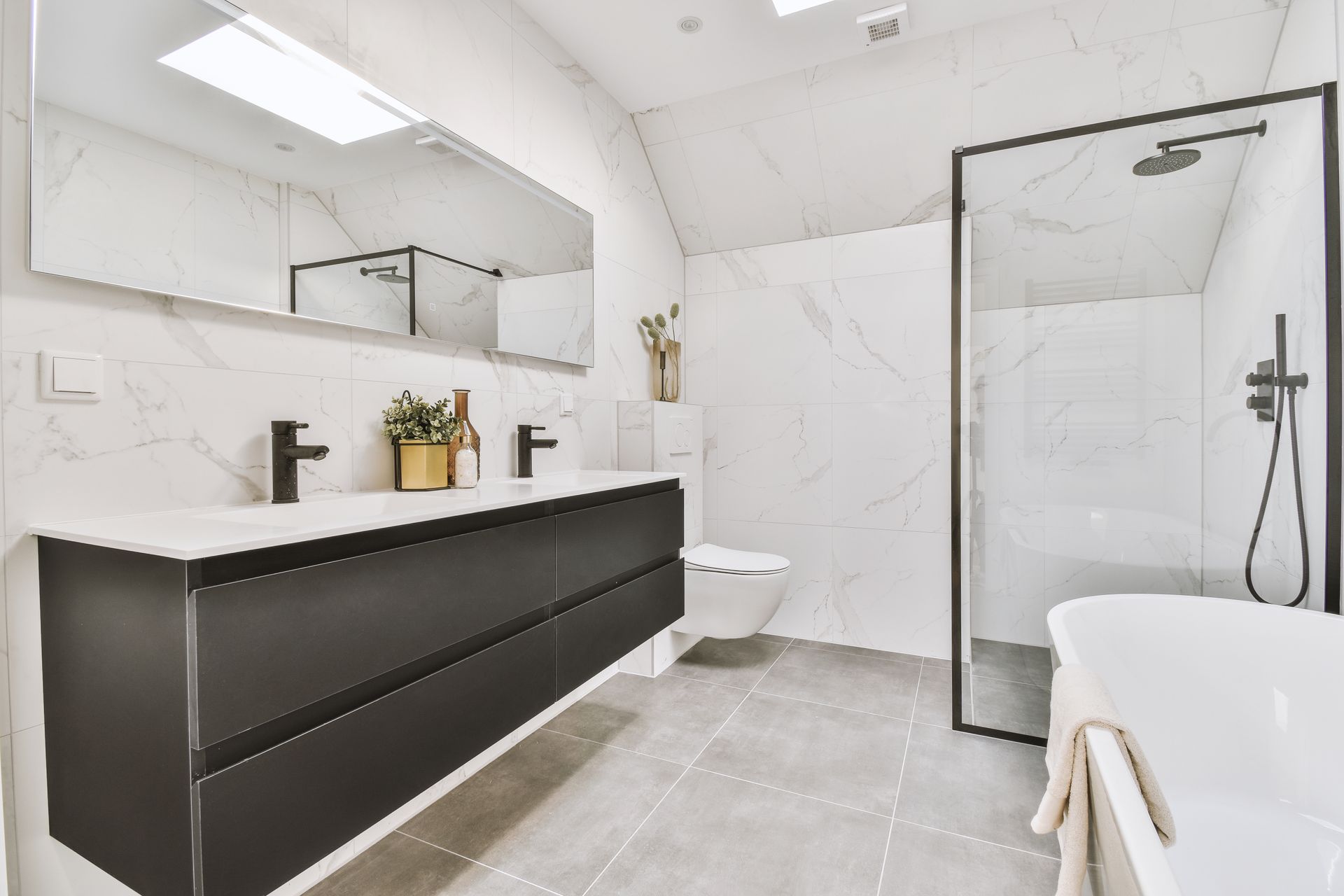 Une salle de bain avec deux lavabos, un WC et une baignoire.