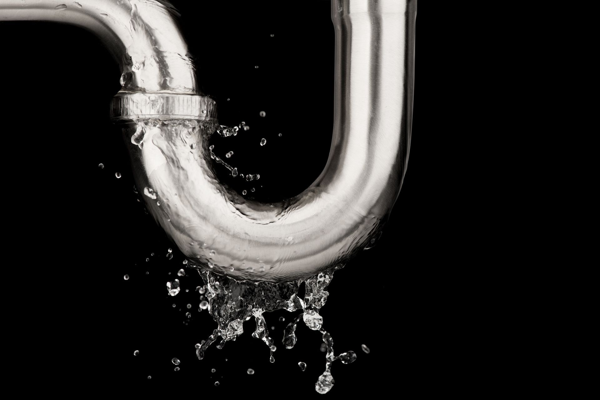 Un tuyau en acier inoxydable avec de l'eau qui en sort sur un fond noir.