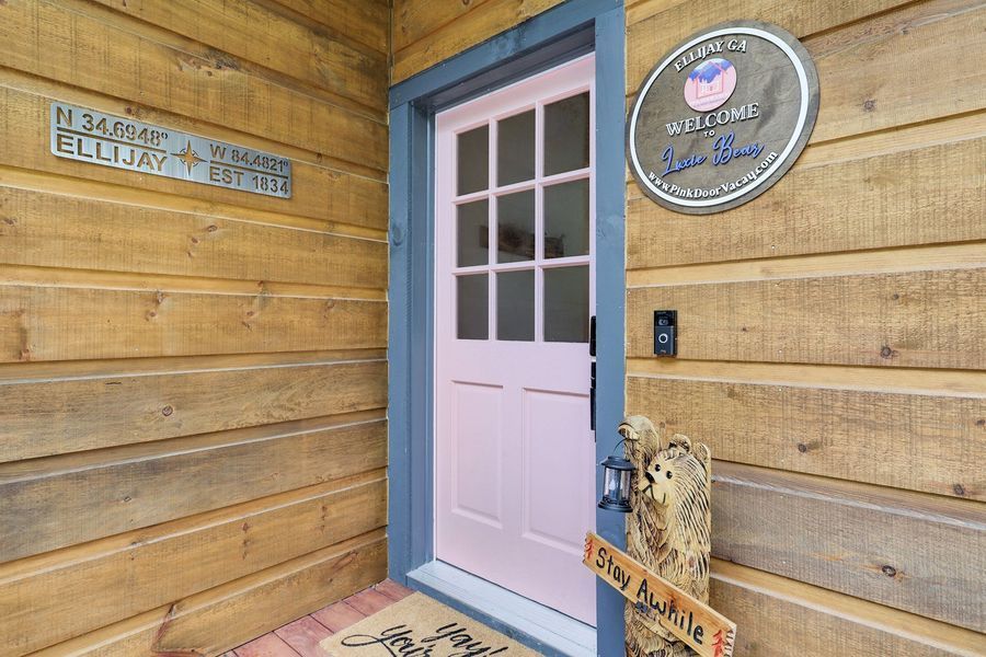 Pink door with blue trim, wooden exterior, and 