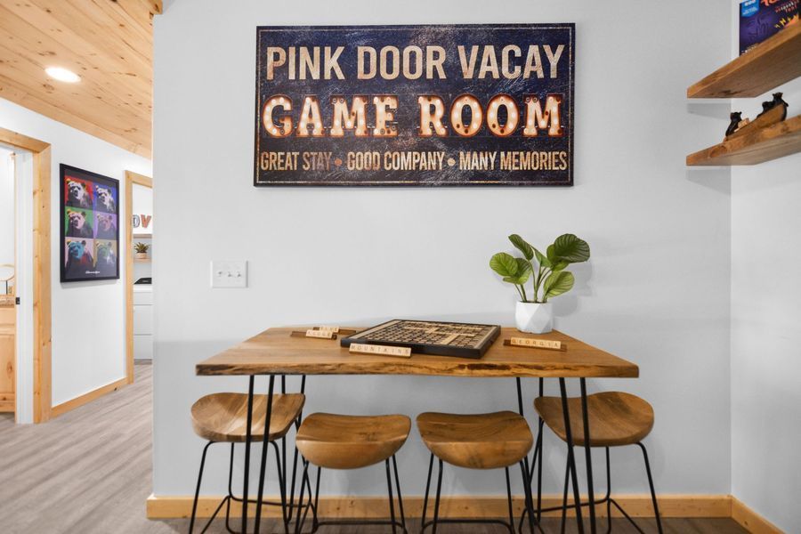 Game room with table, stools, and sign that says 