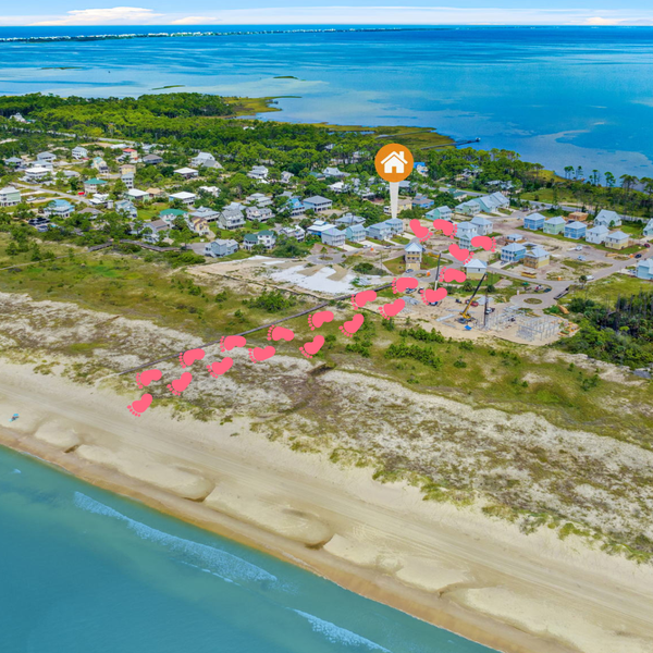 Aerial view of a coastal neighborhood, with a path of pink hearts leading from the beach towards a house icon.