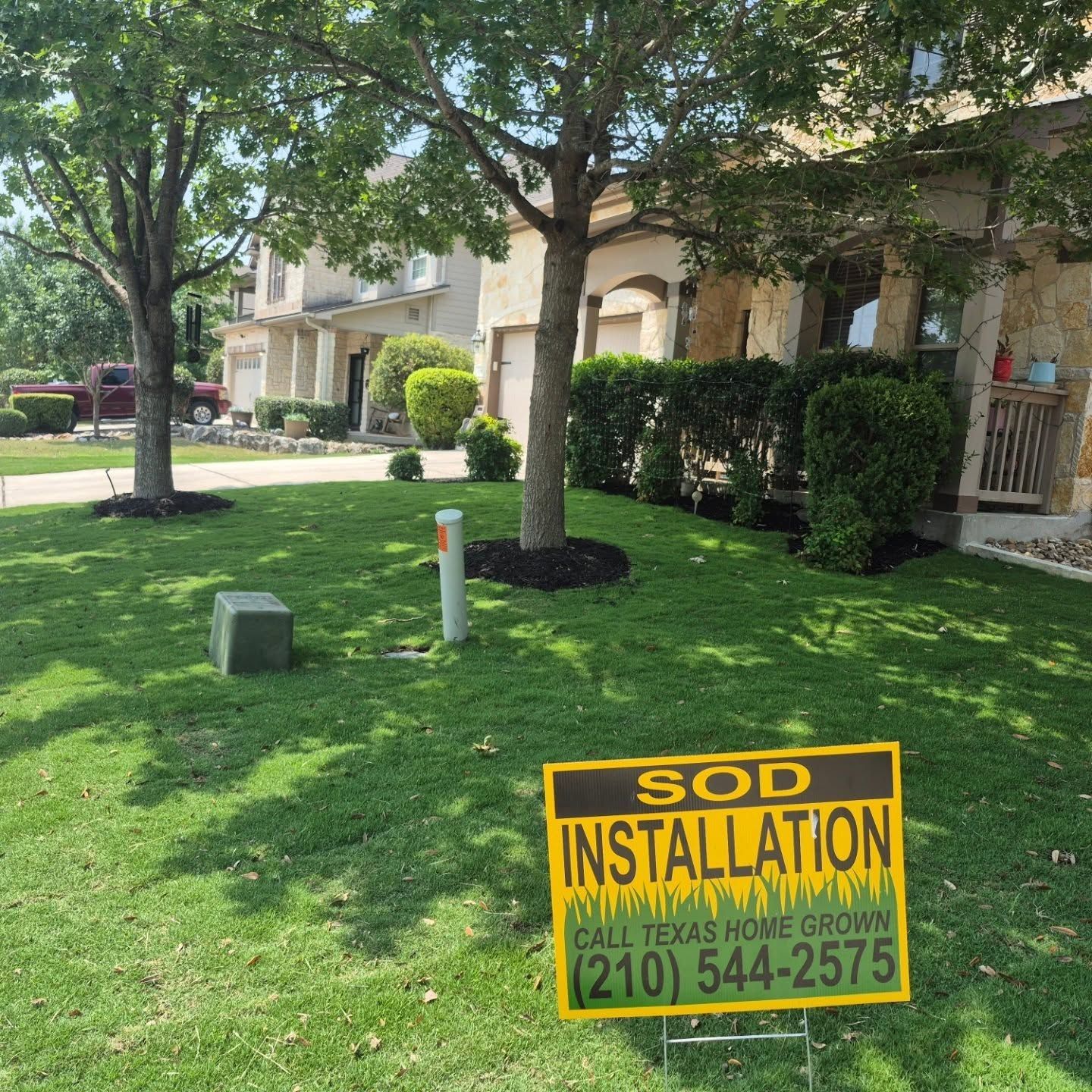 Lawn with newly installed sod, sign reads 