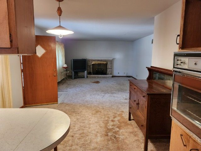 A living room with a fireplace and a dresser