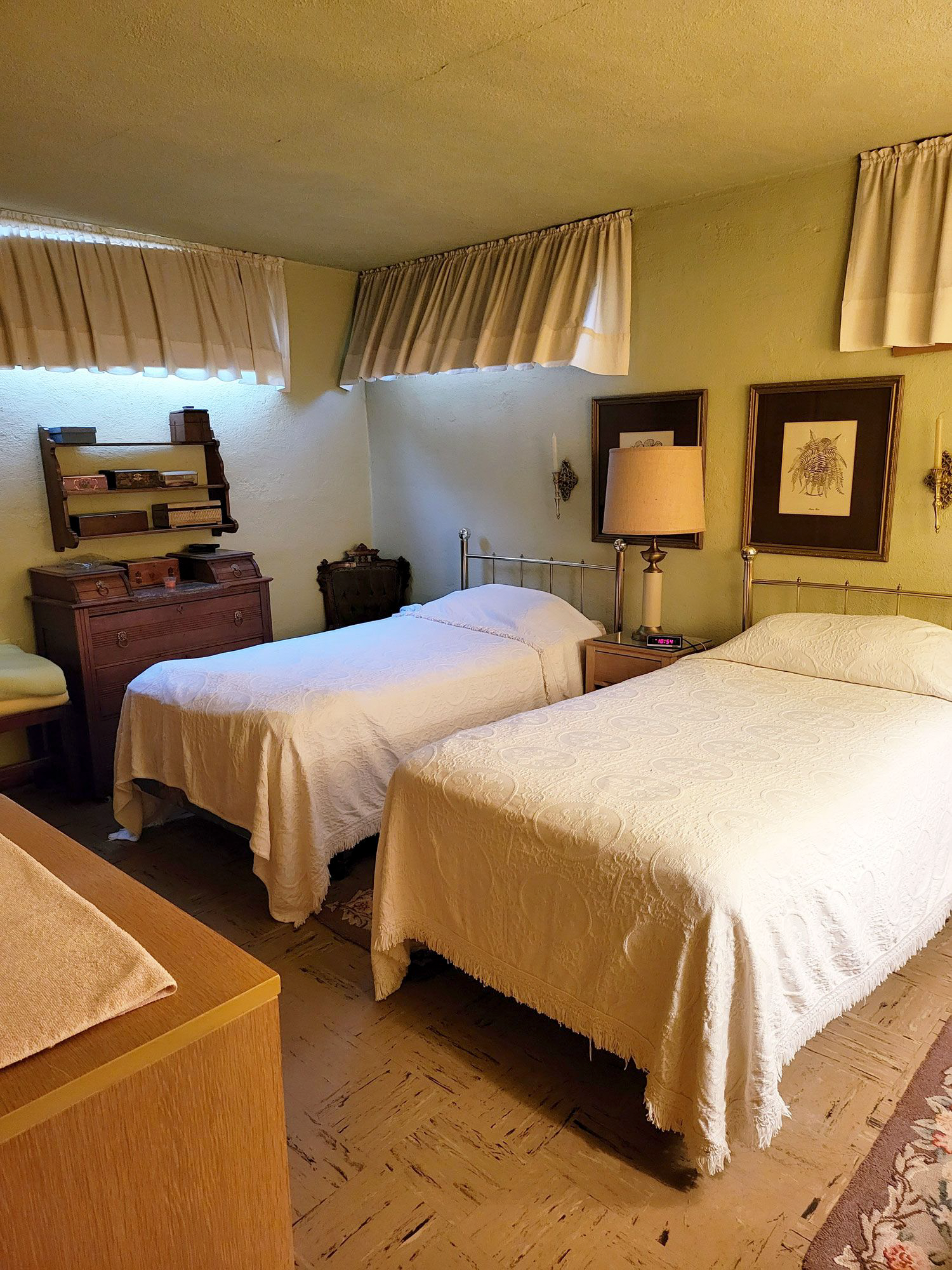 A bedroom with two twin beds and a dresser