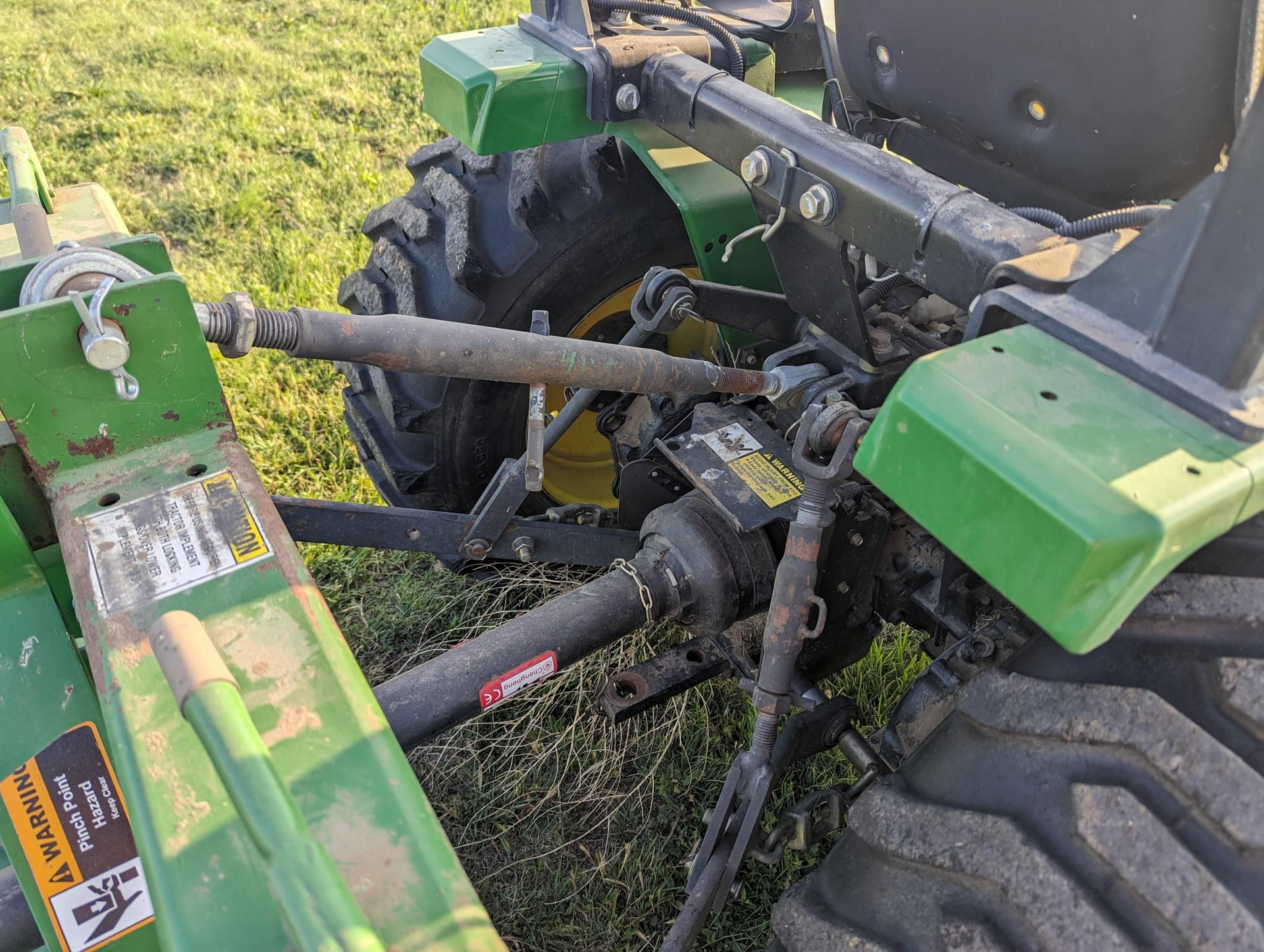 A green tractor is parked in a grassy field.