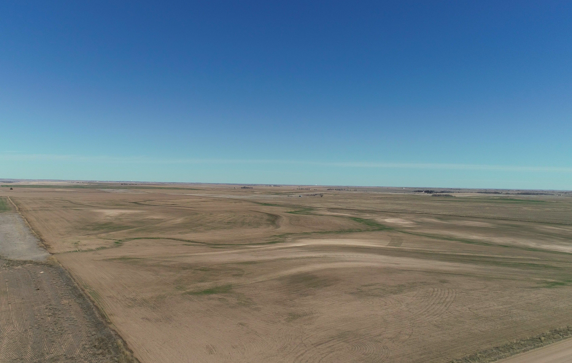 An aerial view of a dirt road going through a desert landscape.