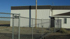 A chain link fence is in front of a building.