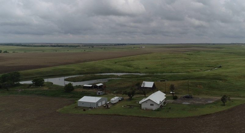 An aerial view of a small farm in the middle of a field.