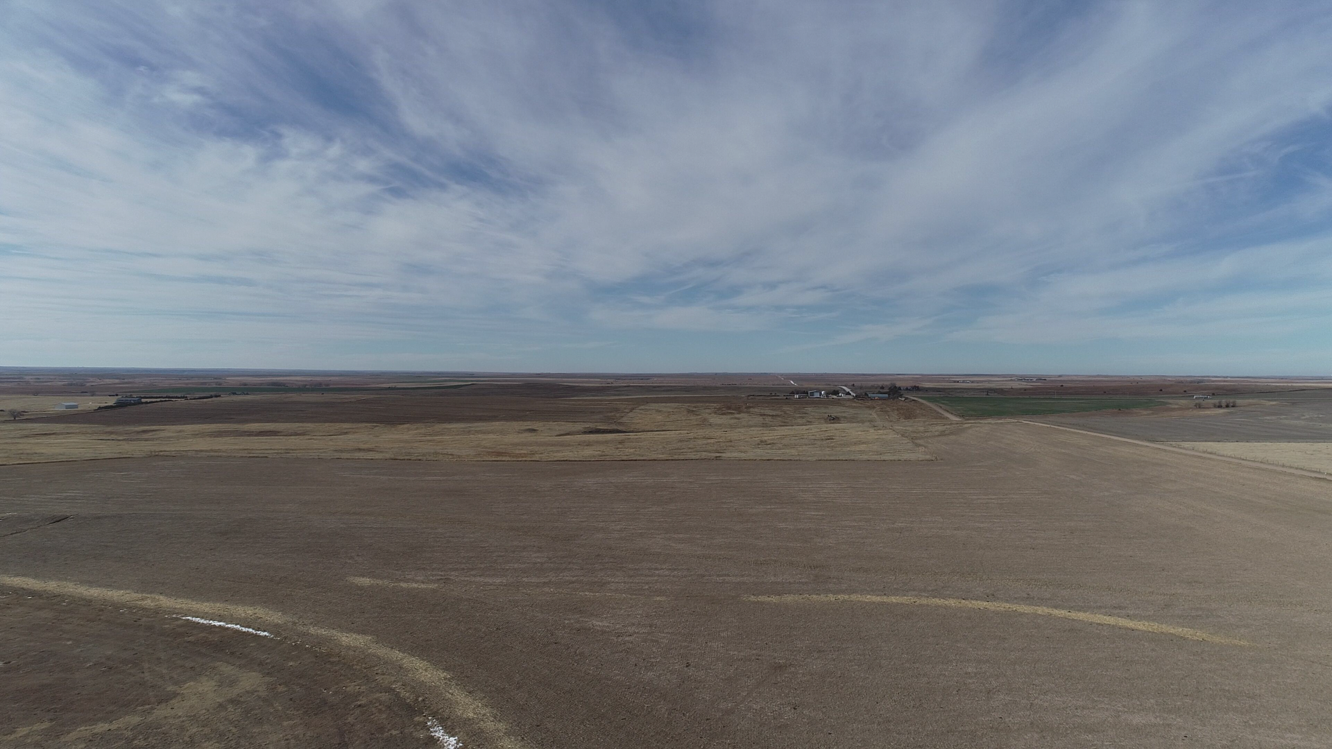 An aerial view of a desert landscape with a blue sky and clouds.