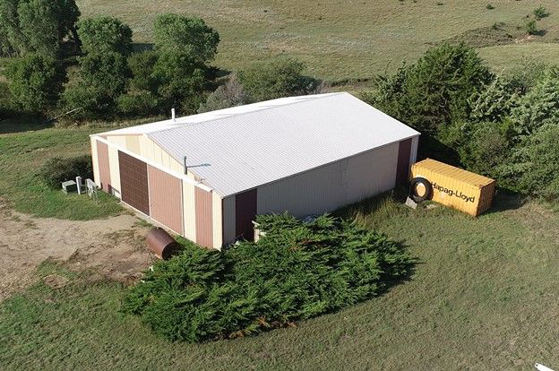 An aerial view of a large building in a field
