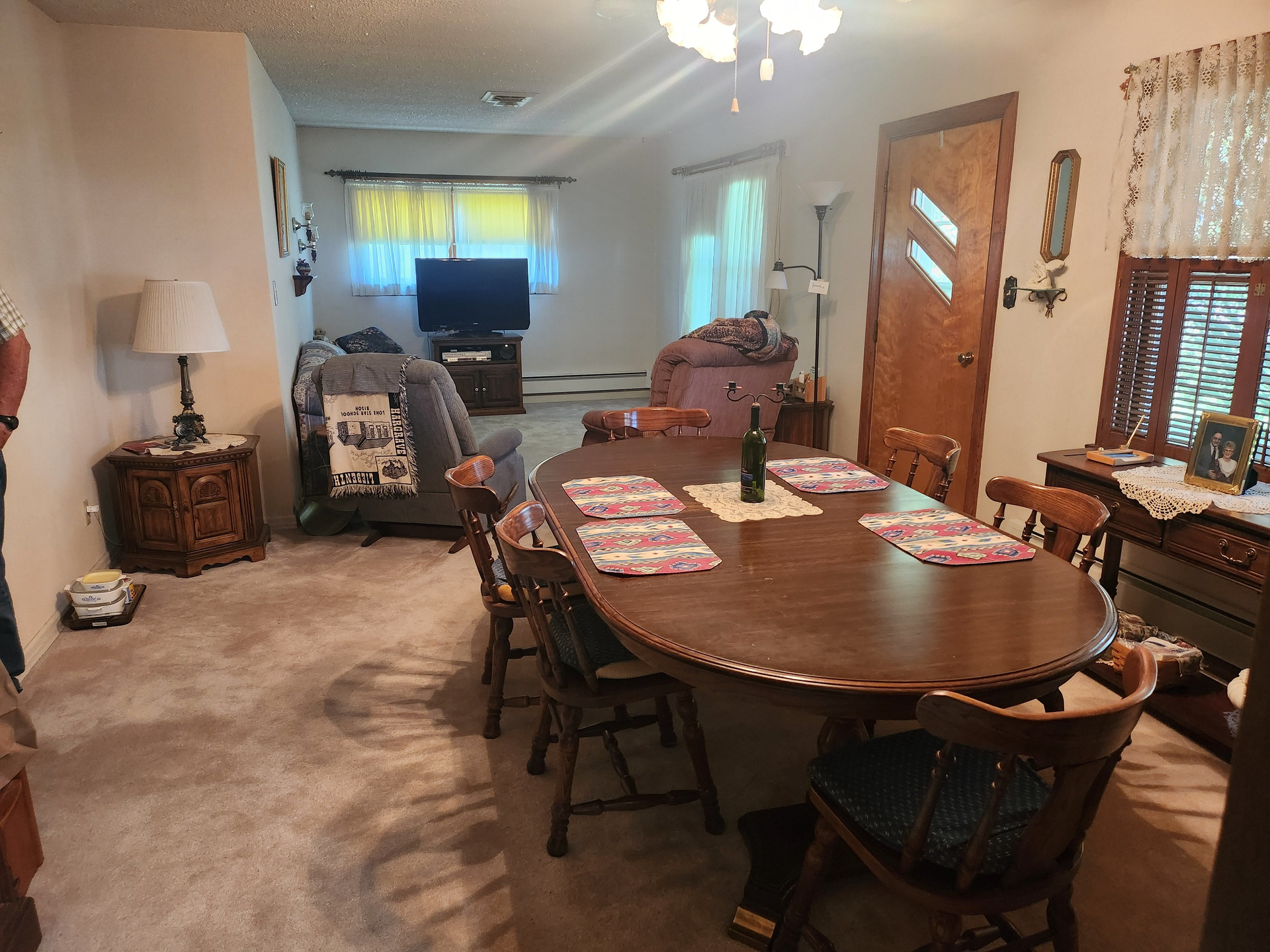 A living room with a table and chairs and a television.