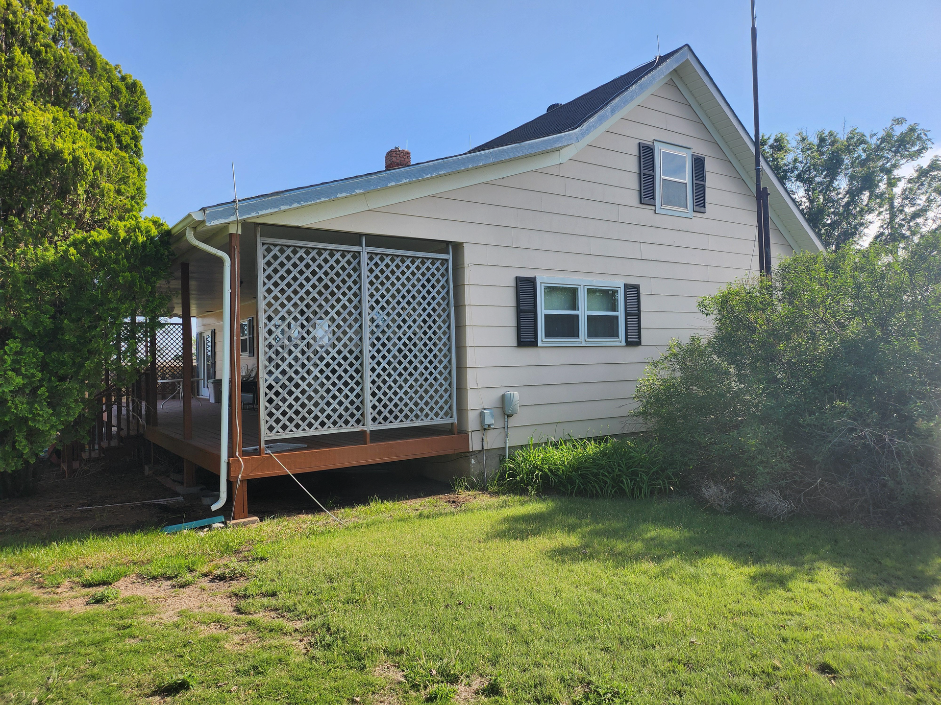 A small white house with a porch and shutters