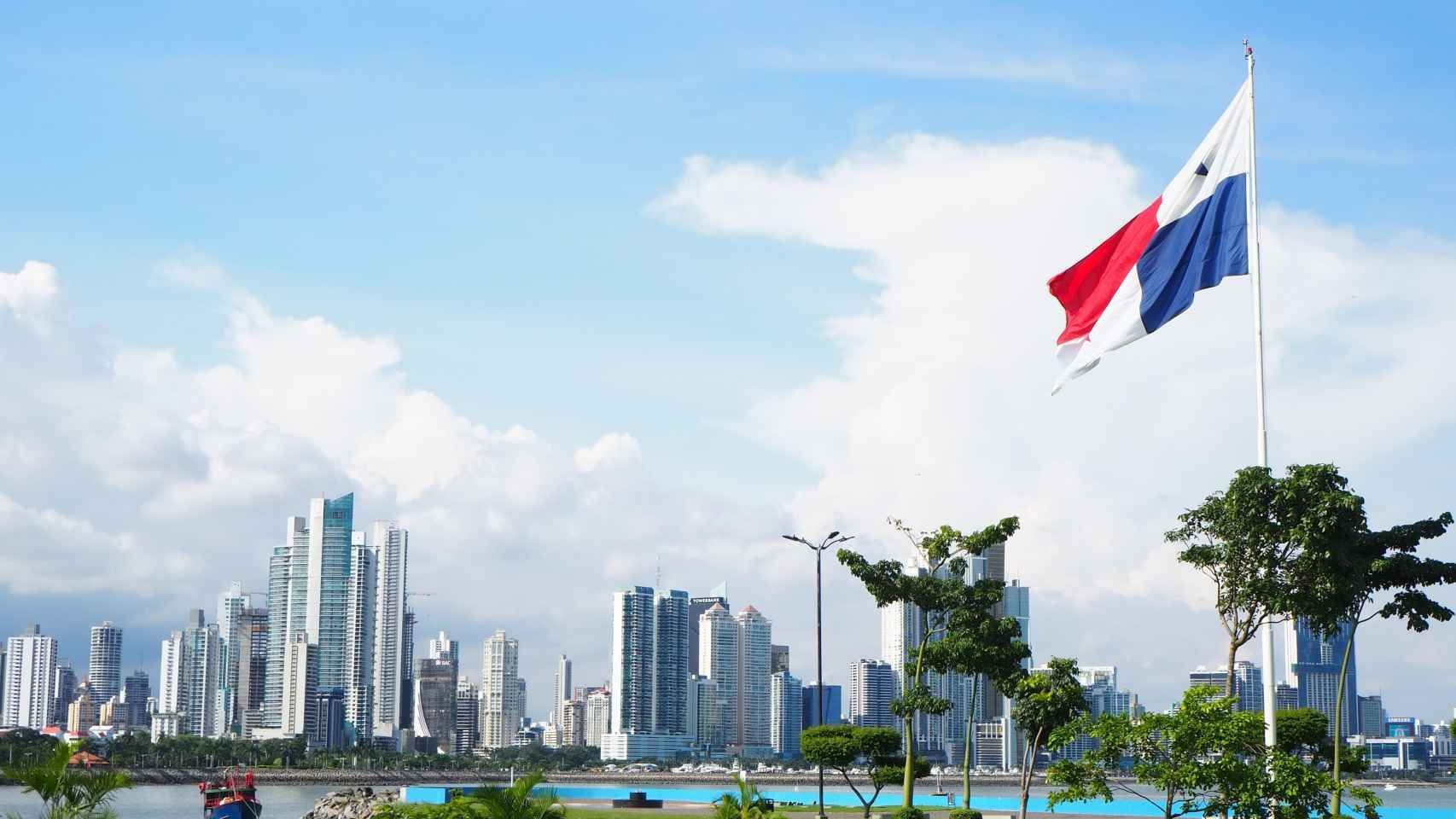 Una bandera ondea frente al horizonte de una ciudad.