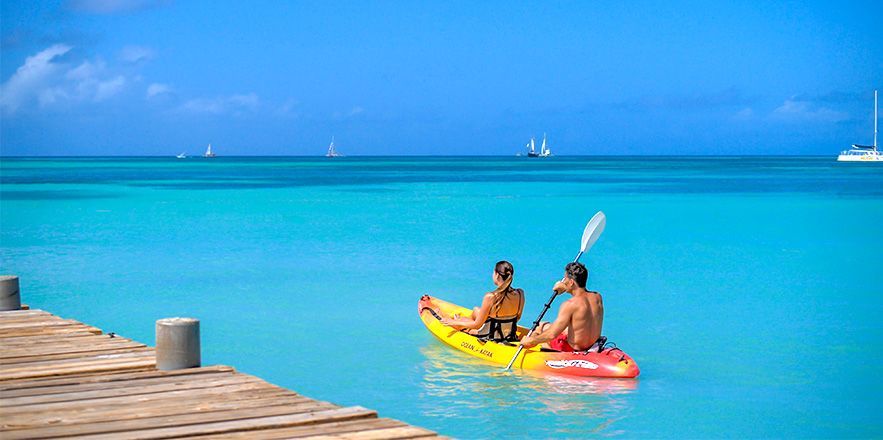 Un hombre y una mujer están sentados en un kayak en el océano.