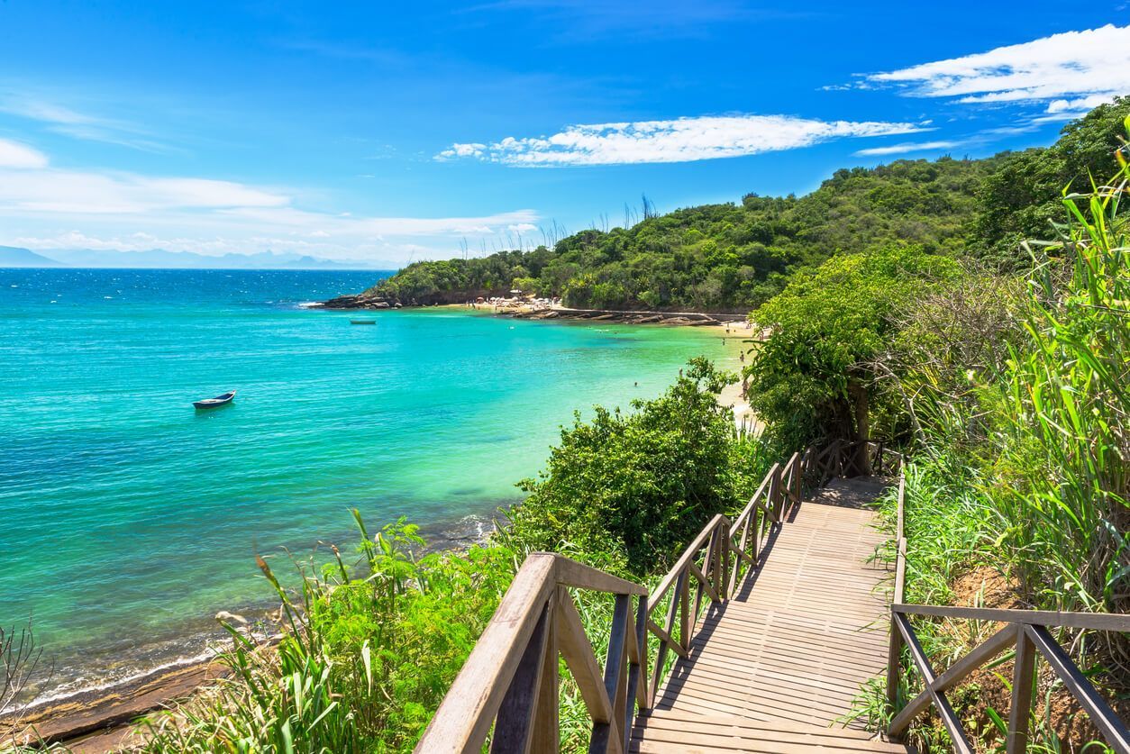 Un hombre y una mujer caminan por una playa con palmeras.