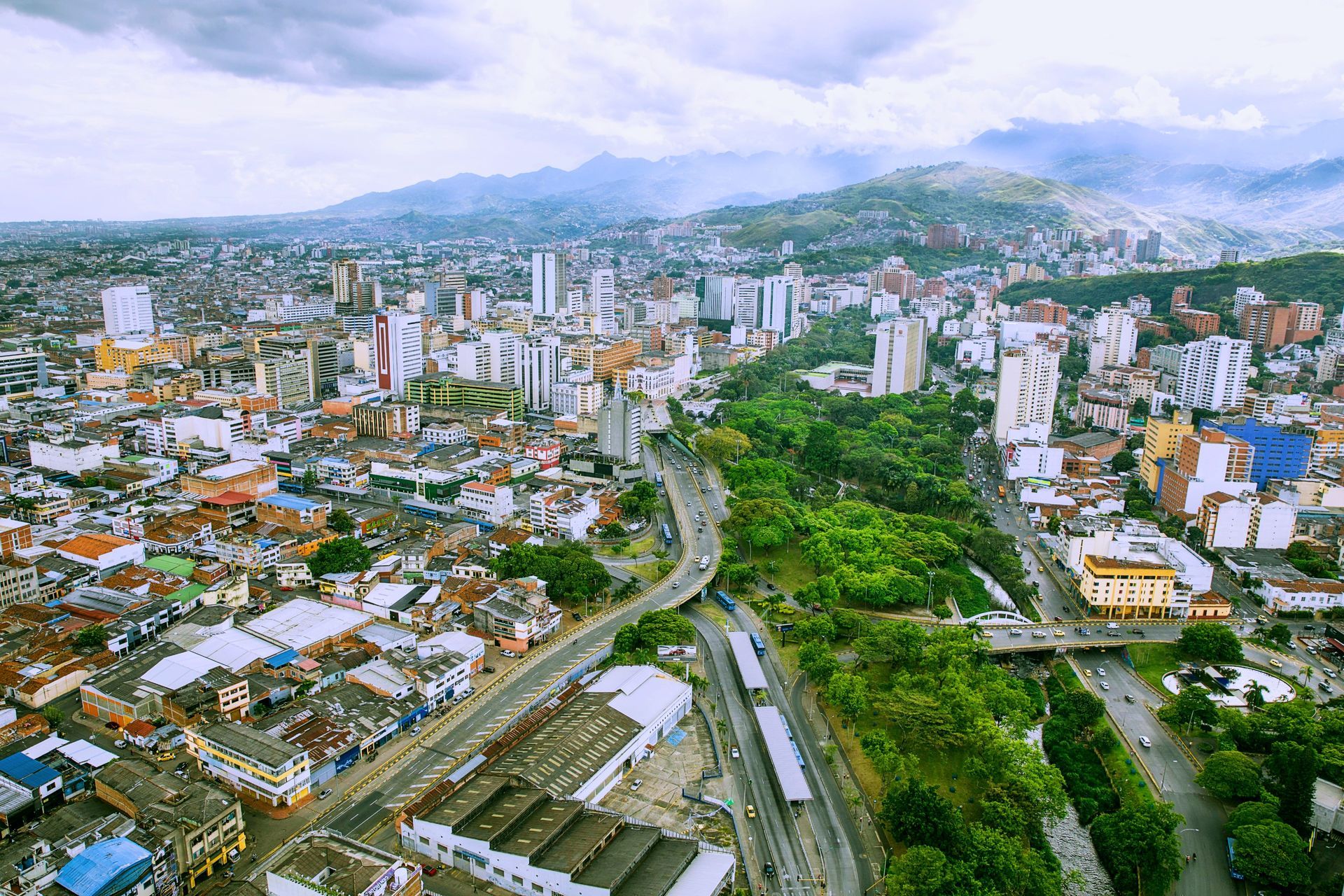 Una calle estrecha bordeada de edificios y balcones con una torre de reloj al fondo.