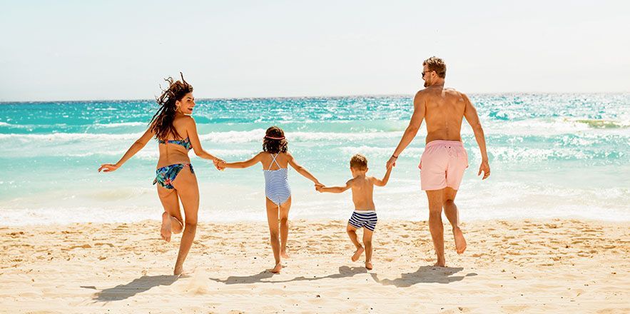 Un grupo de personas está jugando en el océano en una playa.