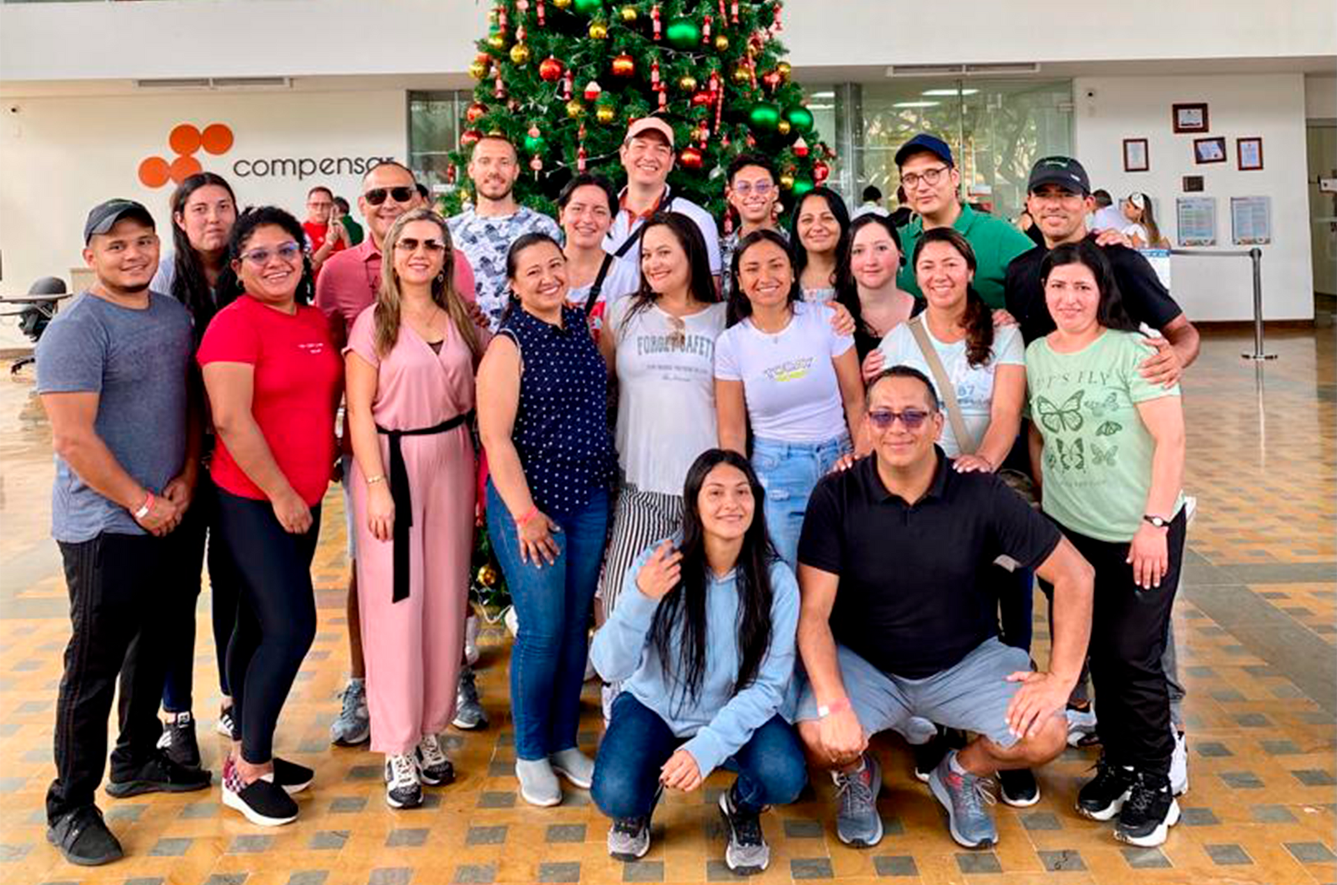 Un grupo de personas posan para una foto frente a un árbol de Navidad.