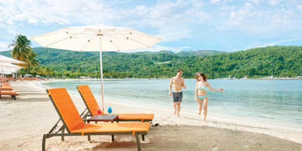 Un hombre y una mujer caminan por la playa.