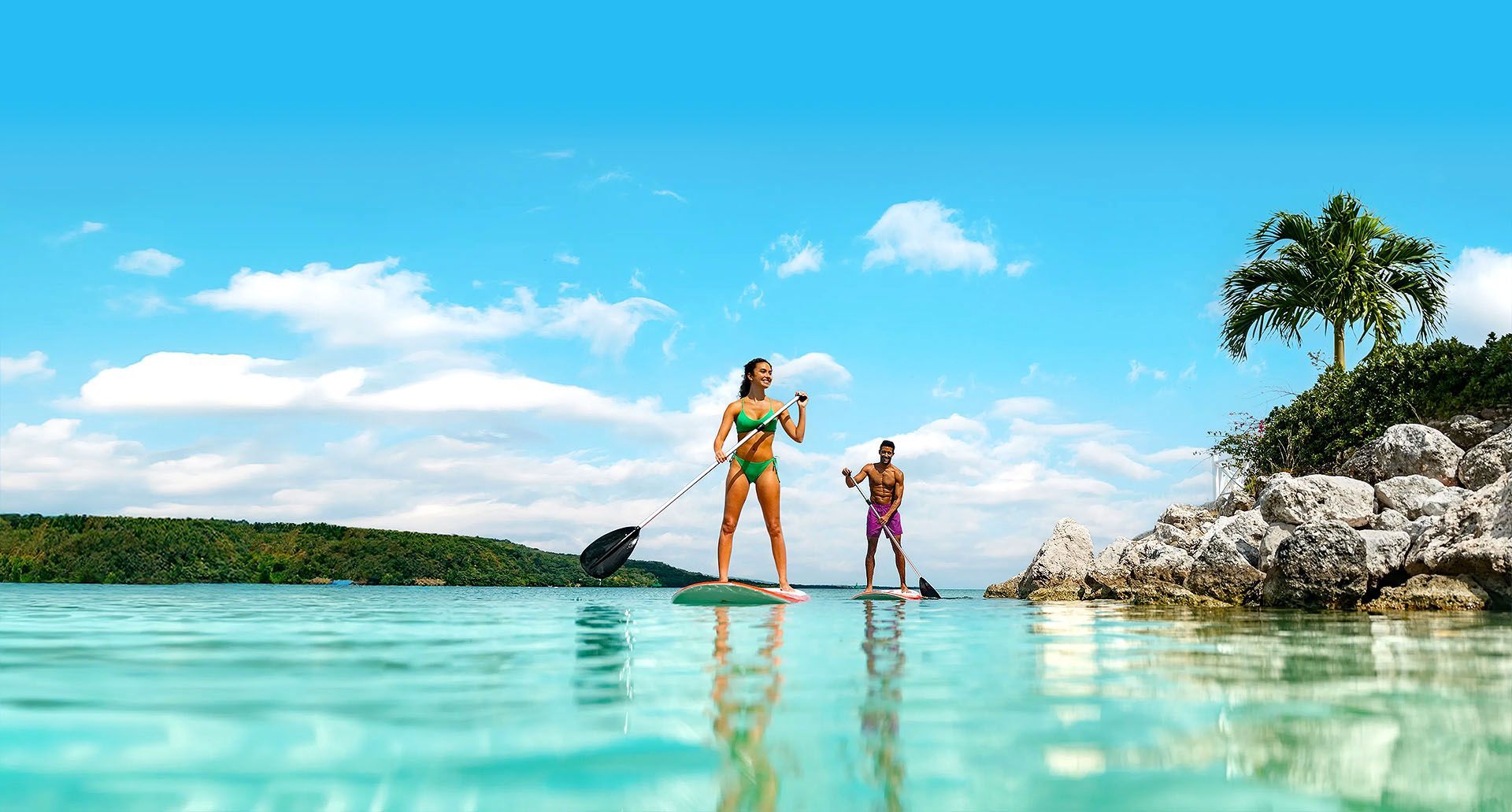 Un grupo de personas está jugando en el océano en una playa.