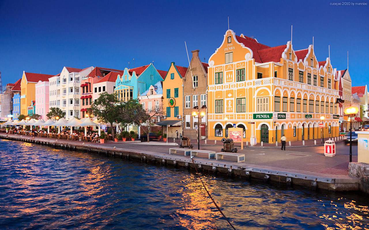 A row of colorful buildings next to a body of water.