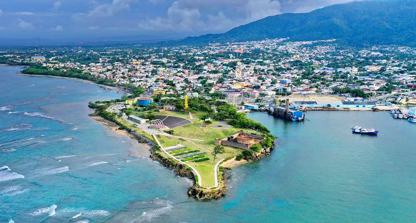 Un hombre y una mujer caminan por una playa con palmeras.