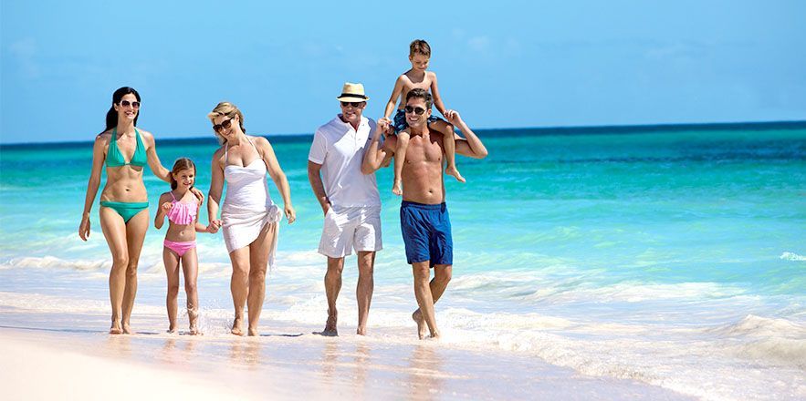 Una familia camina por la playa.