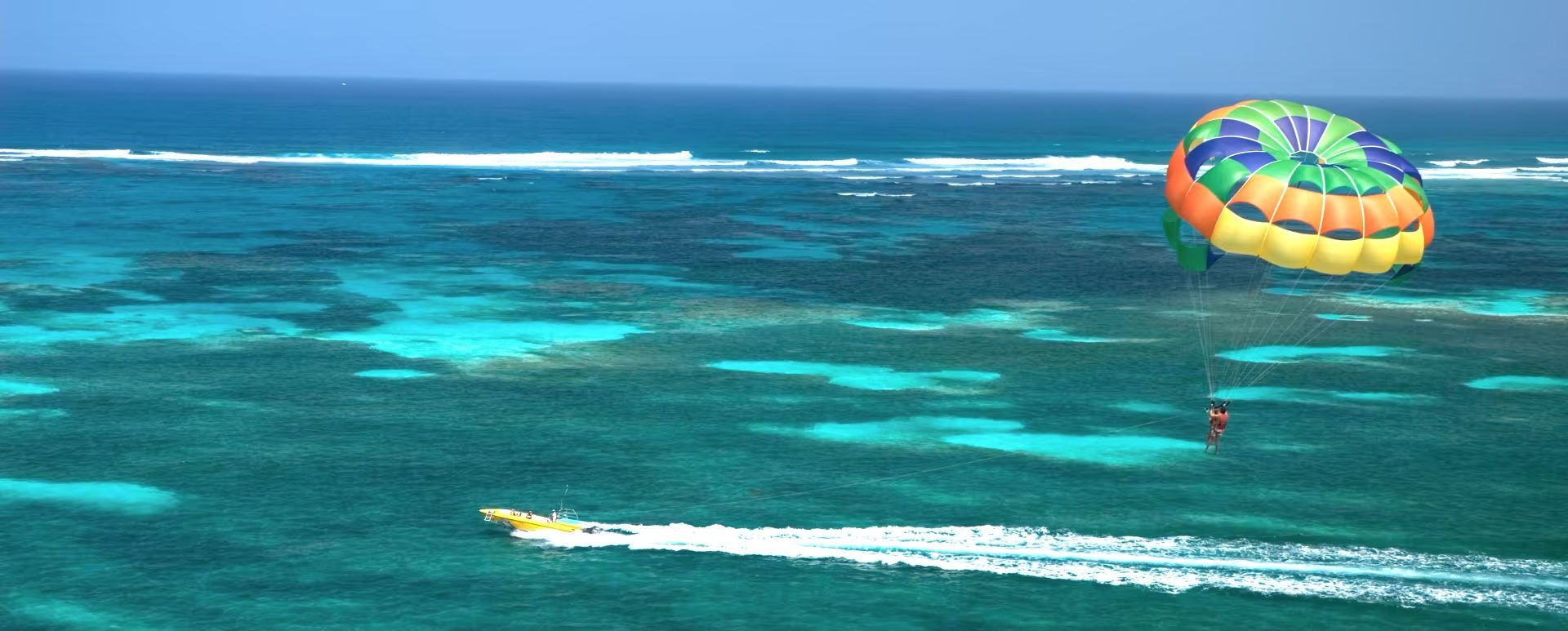 Un hombre y una mujer caminan por una playa con palmeras.