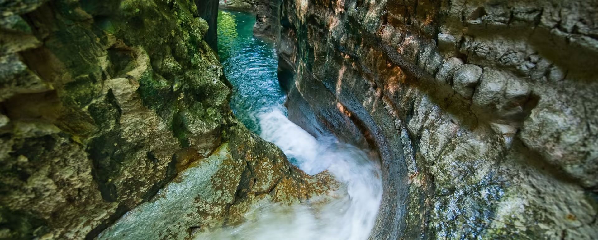 Un río que fluye a través de un estrecho cañón rodeado de rocas.