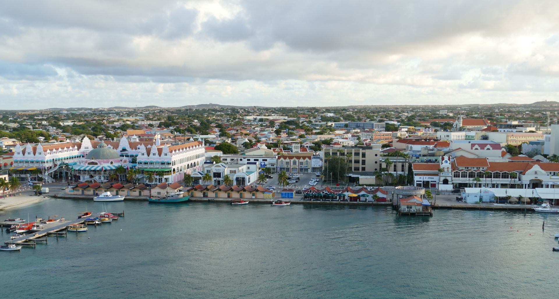 Un hombre y una mujer caminan por la playa tomados de la mano.