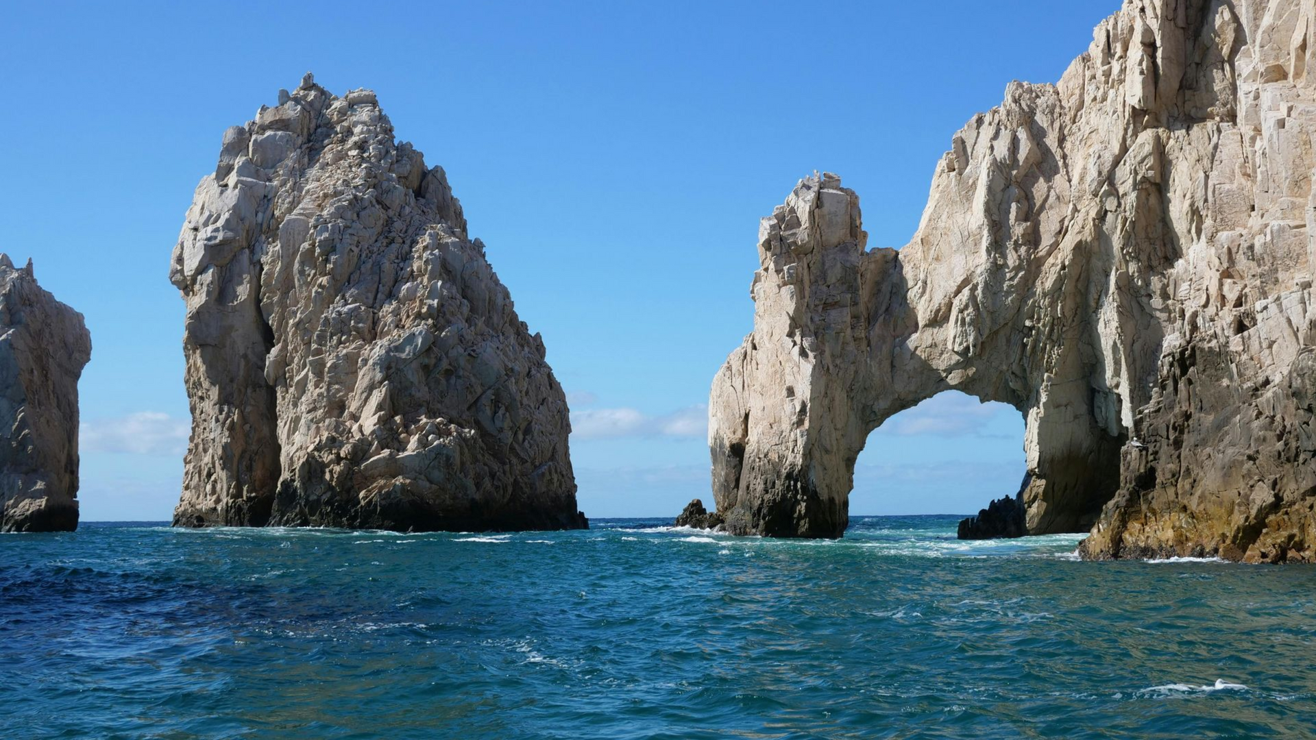 Una persona está formando un corazón con las manos frente a un edificio.