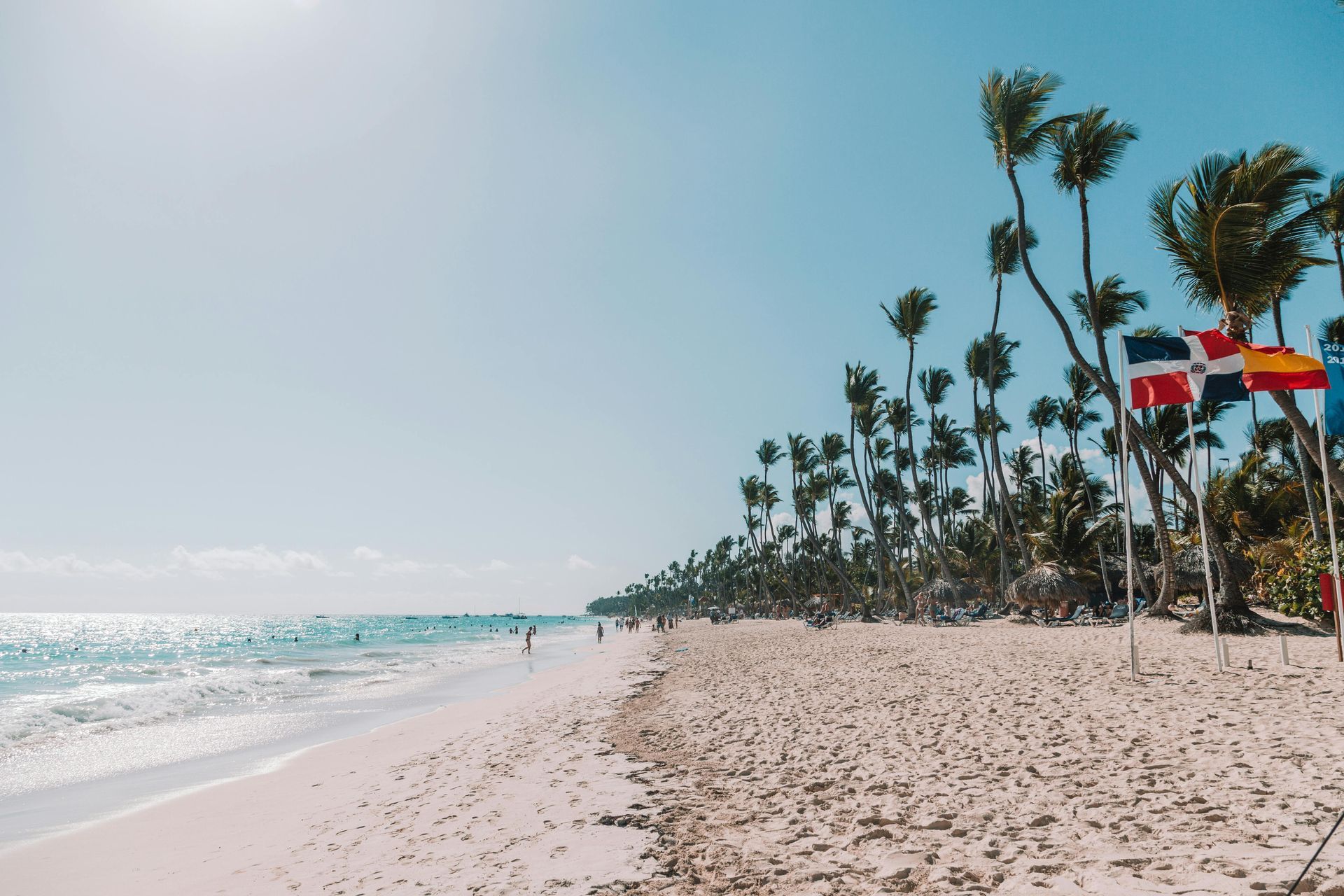 Un hombre y una mujer caminan por una playa con palmeras.