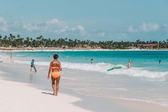 Un hombre y una mujer caminan por la playa.