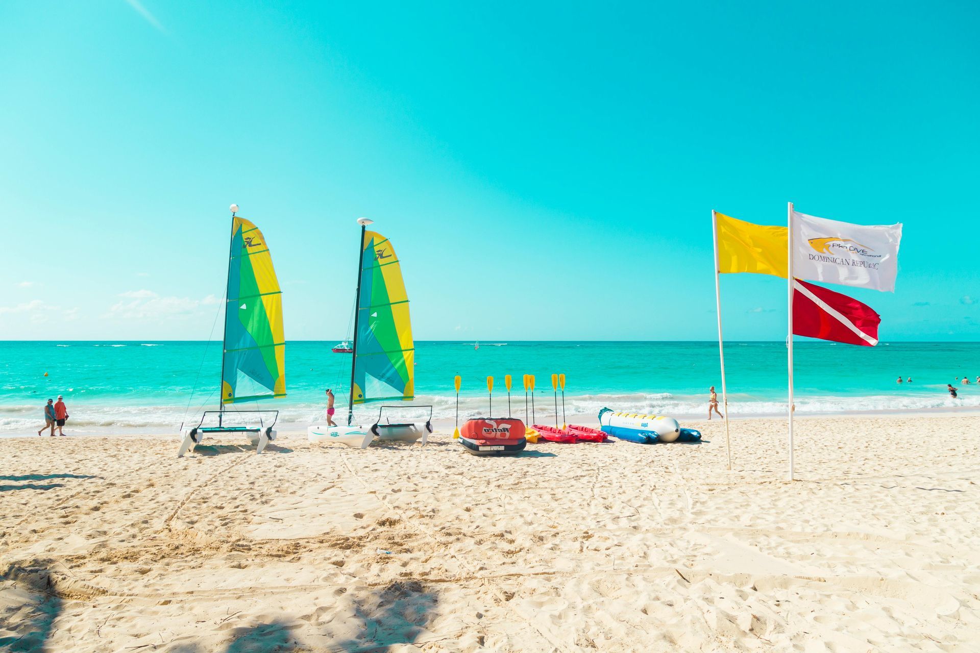 Un hombre y una mujer caminan por una playa con palmeras.
