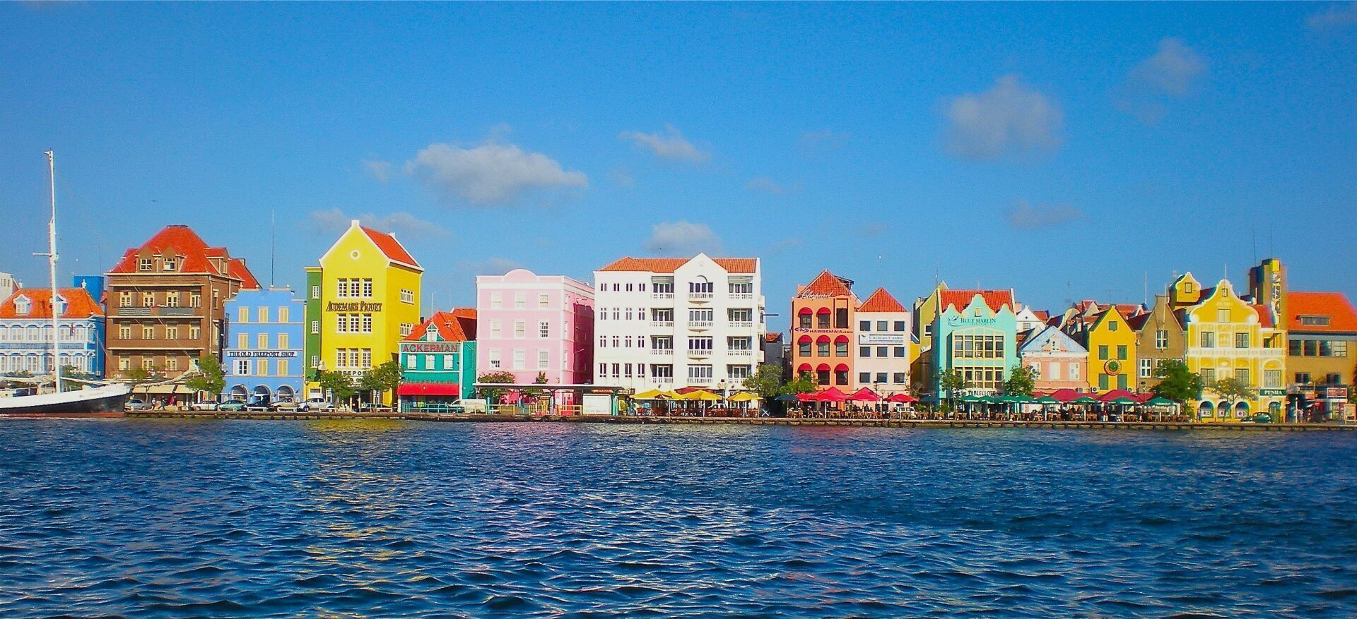 Una hilera de edificios coloridos junto a un cuerpo de agua.