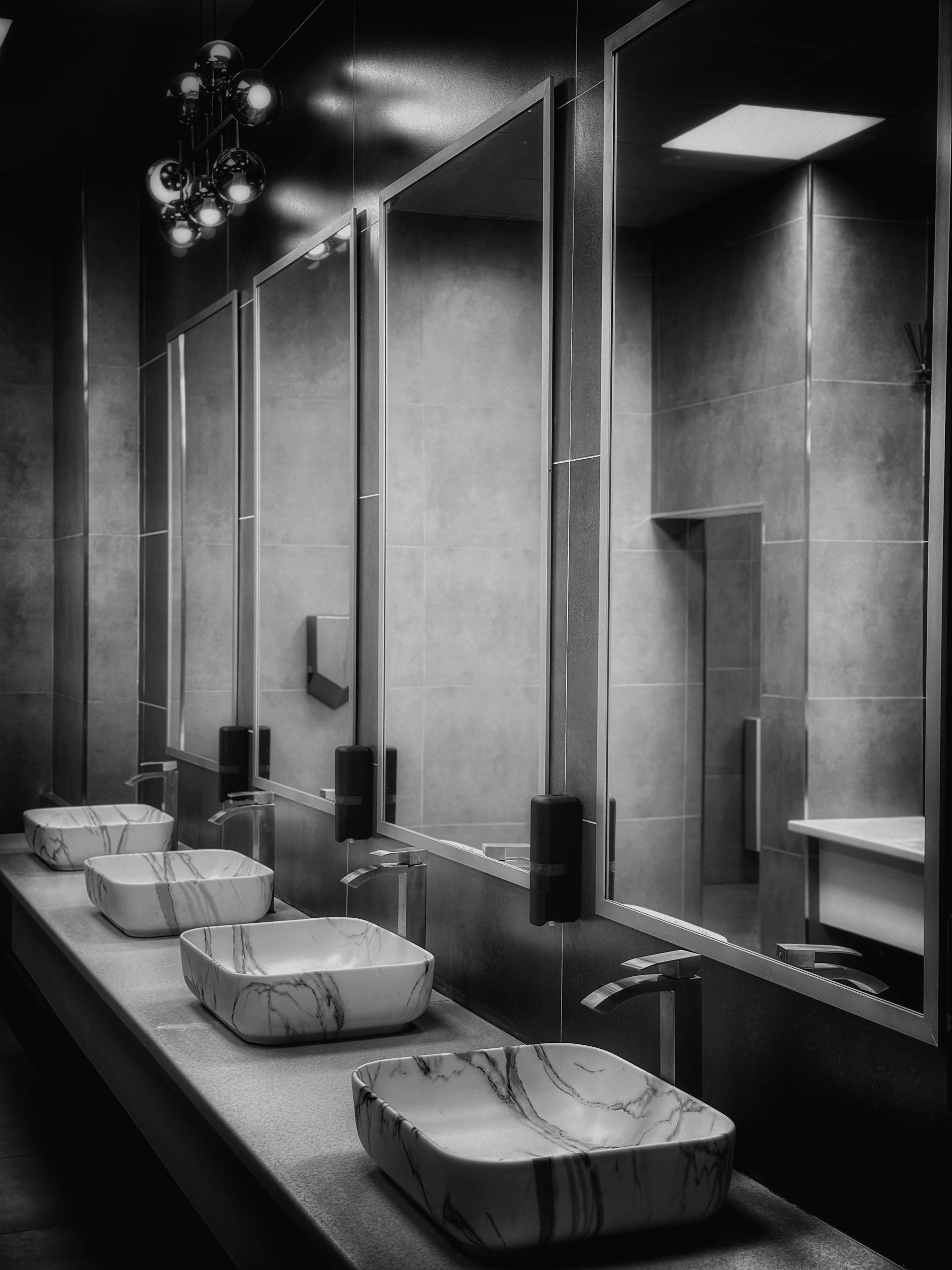 Bathroom with marble sinks, large mirrors, and modern fixtures.