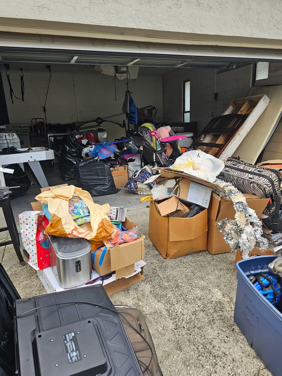 Cluttered garage filled with boxes, bags, and various items. Overstuffed with junk.