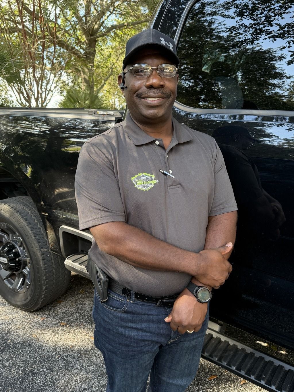 Woman in straw hat smiles, holding wine glass near a lake.