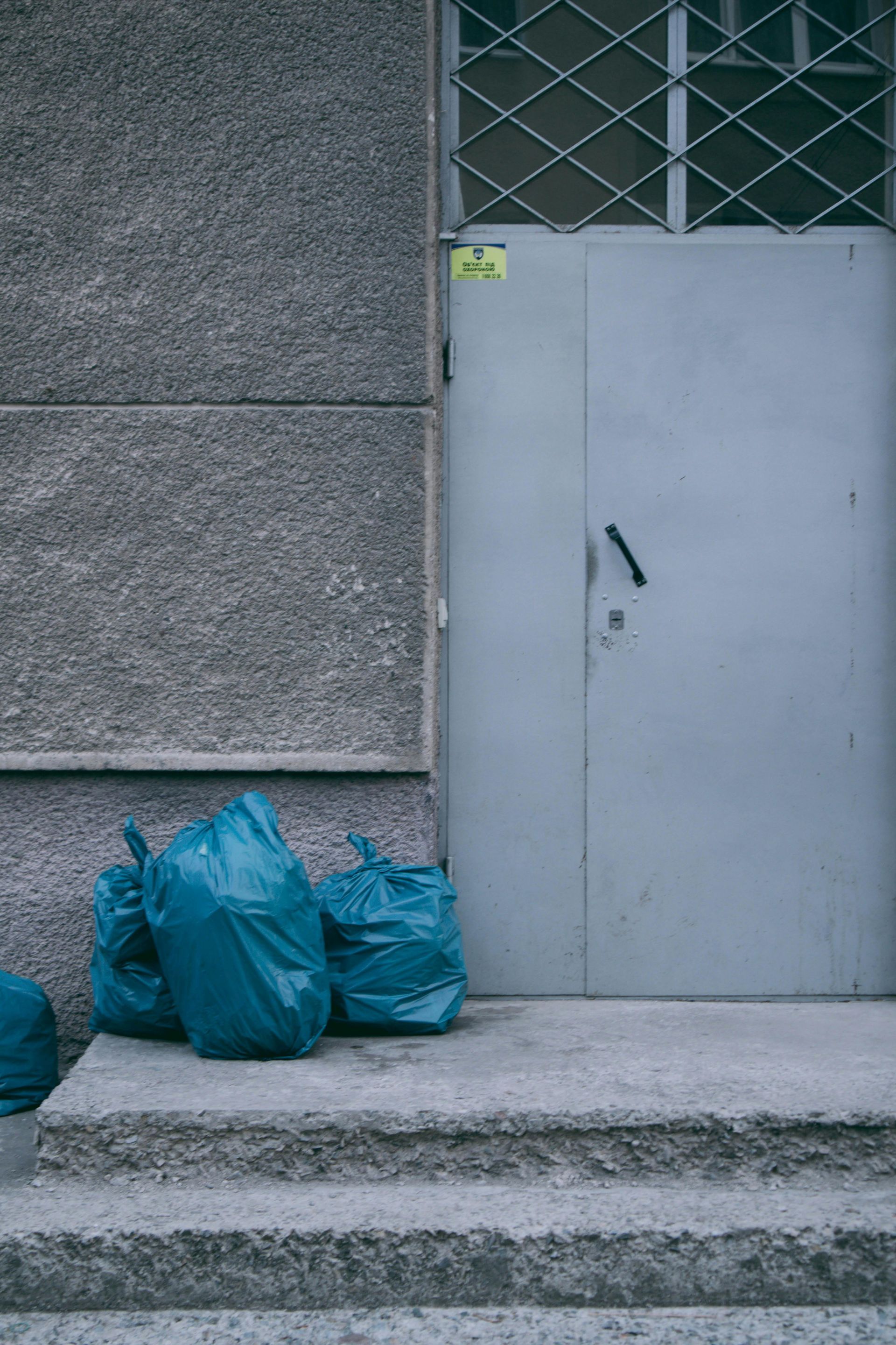 Woman in straw hat smiles, holding wine glass near a lake.