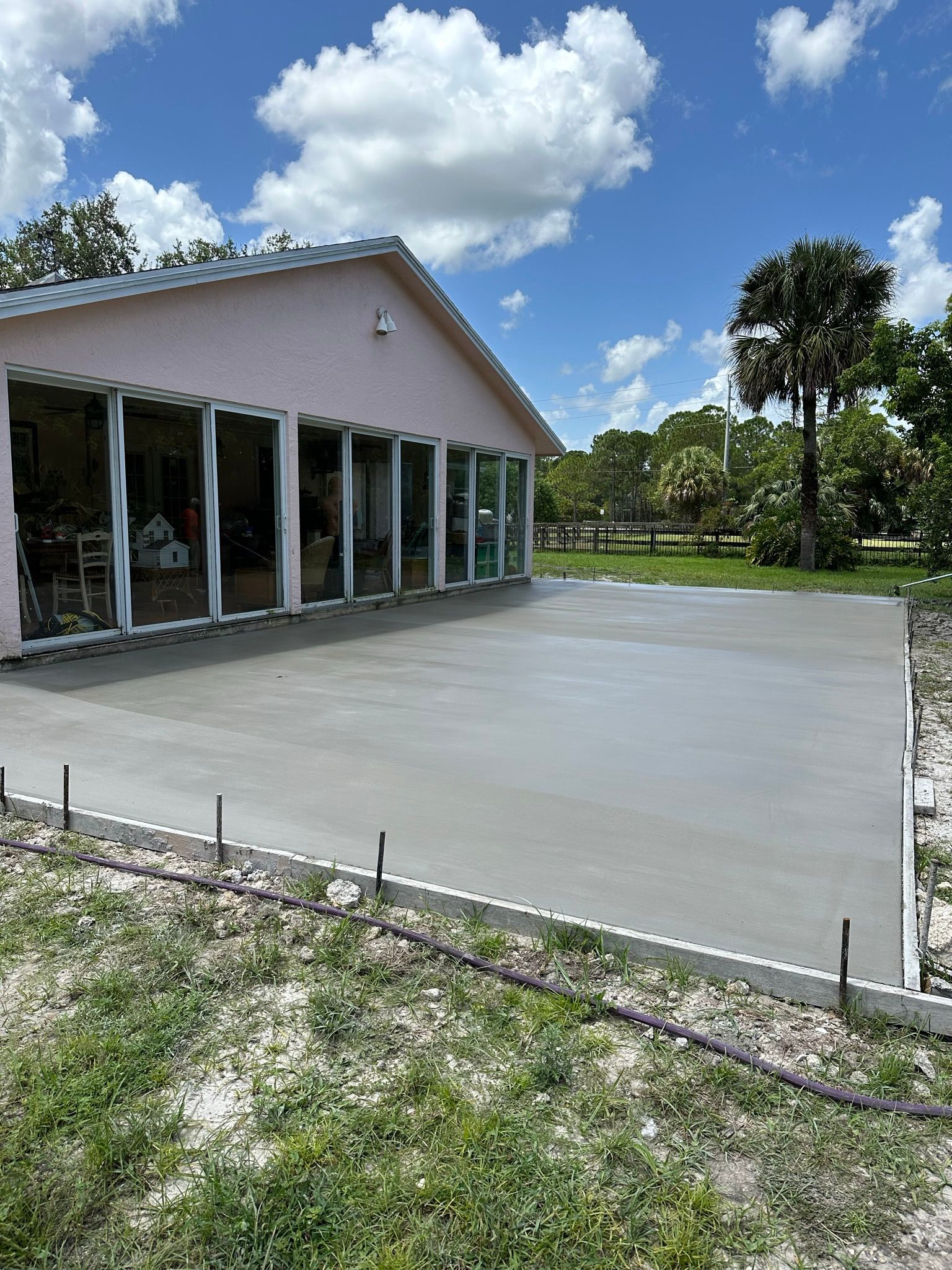 A concrete driveway is being built in front of a house.