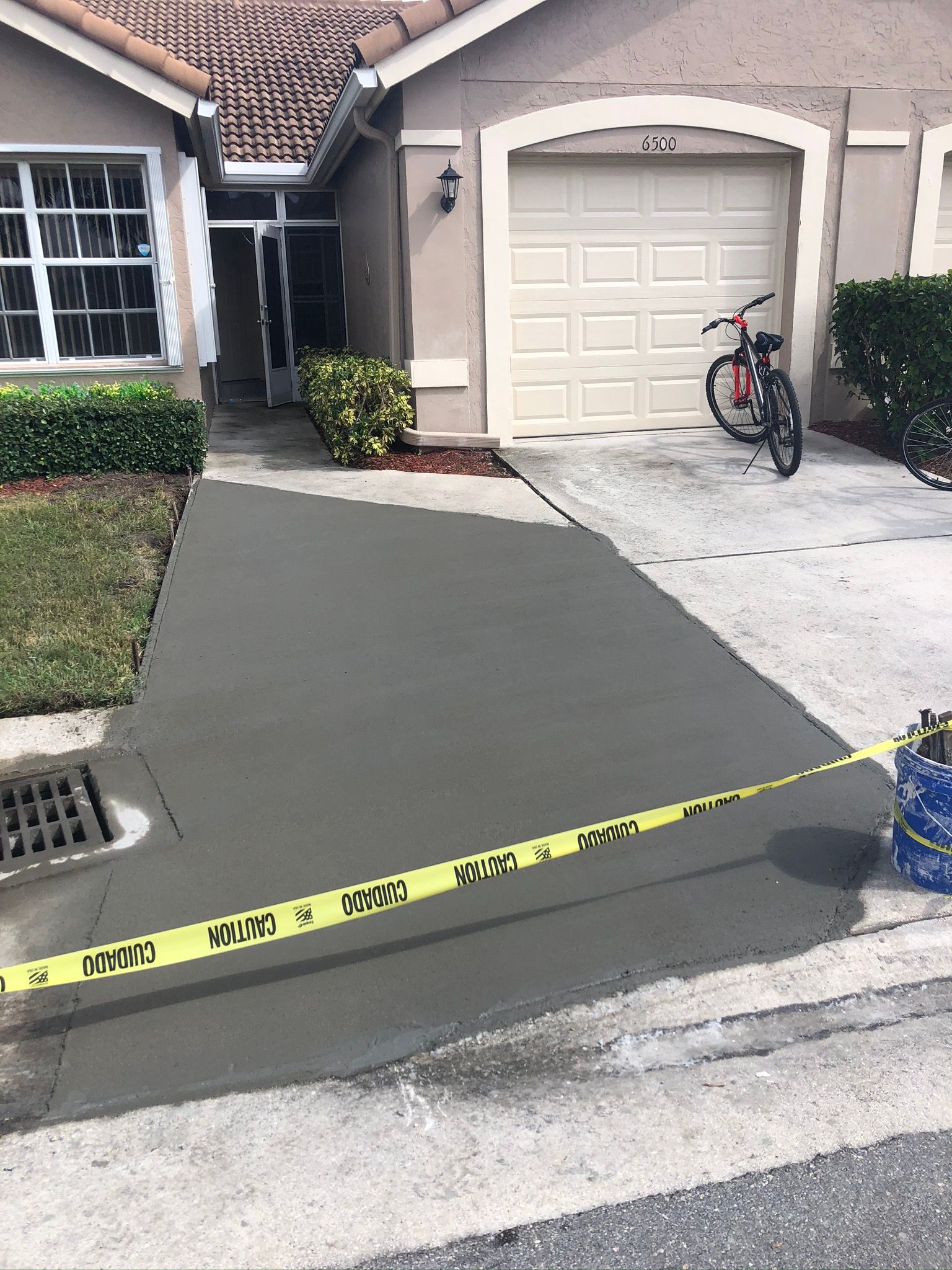 A concrete driveway is being installed in front of a house.