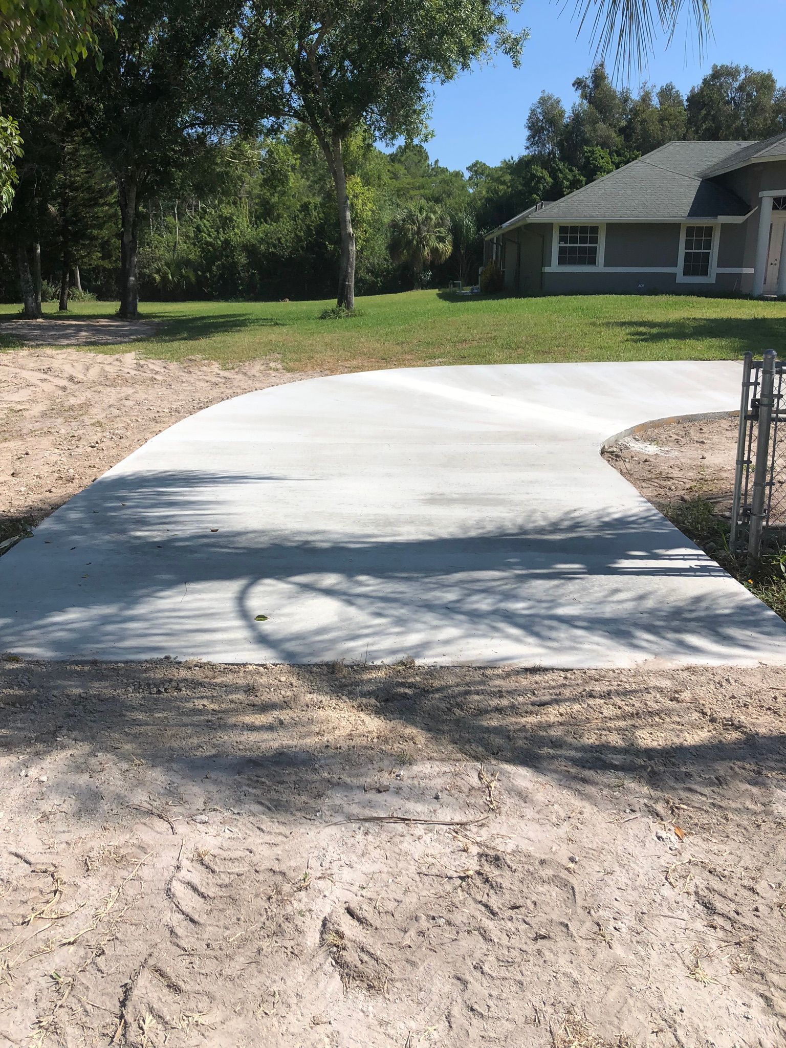 A concrete driveway is being built in front of a house.