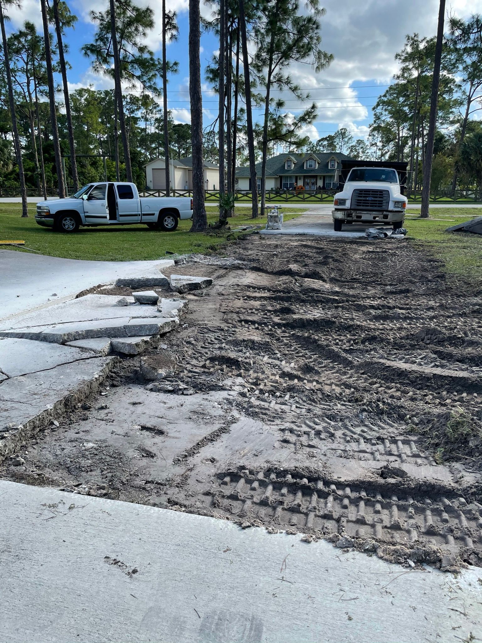 A white truck is parked on the side of a muddy road.