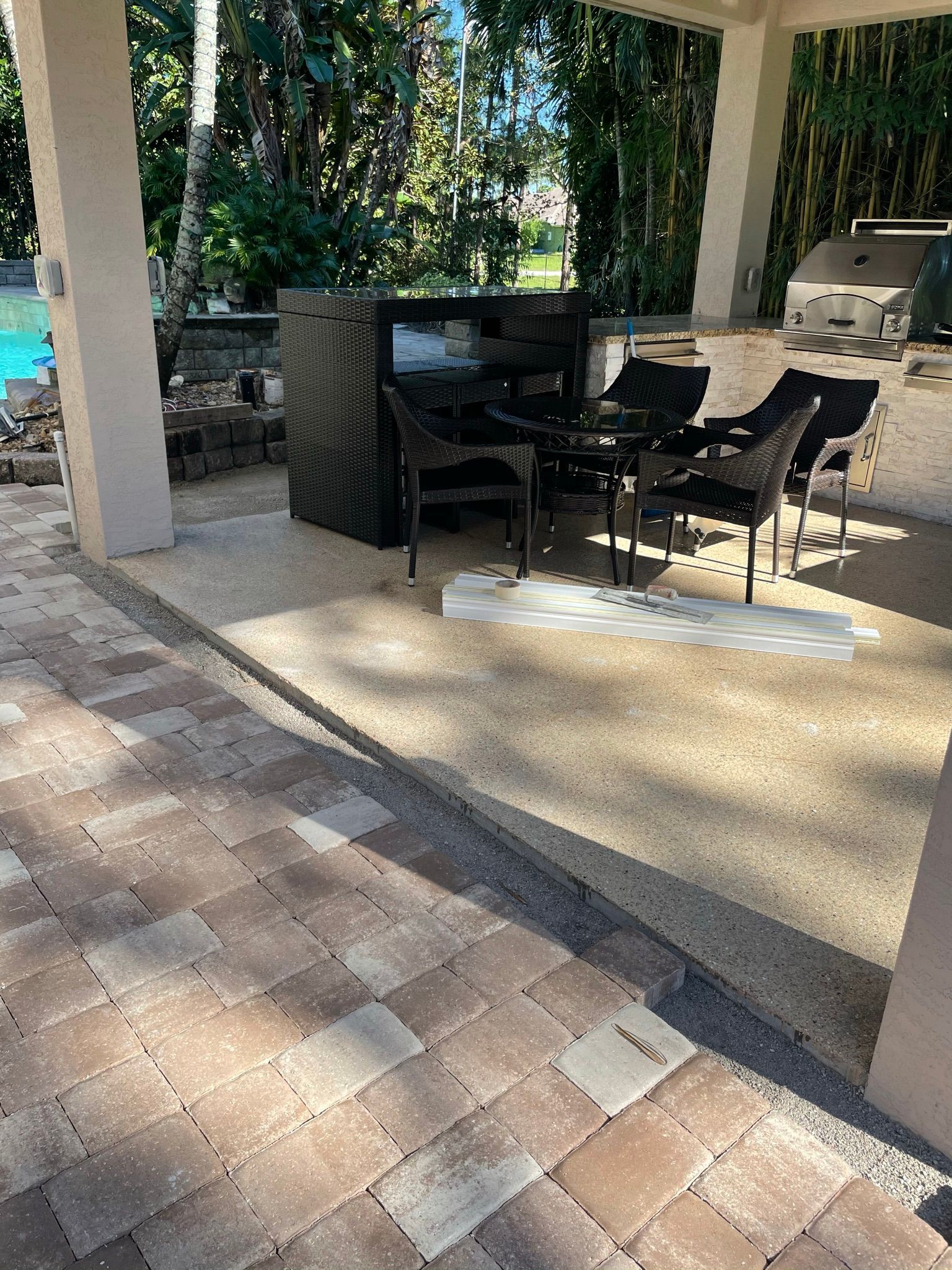 A patio with a table and chairs and a grill.
