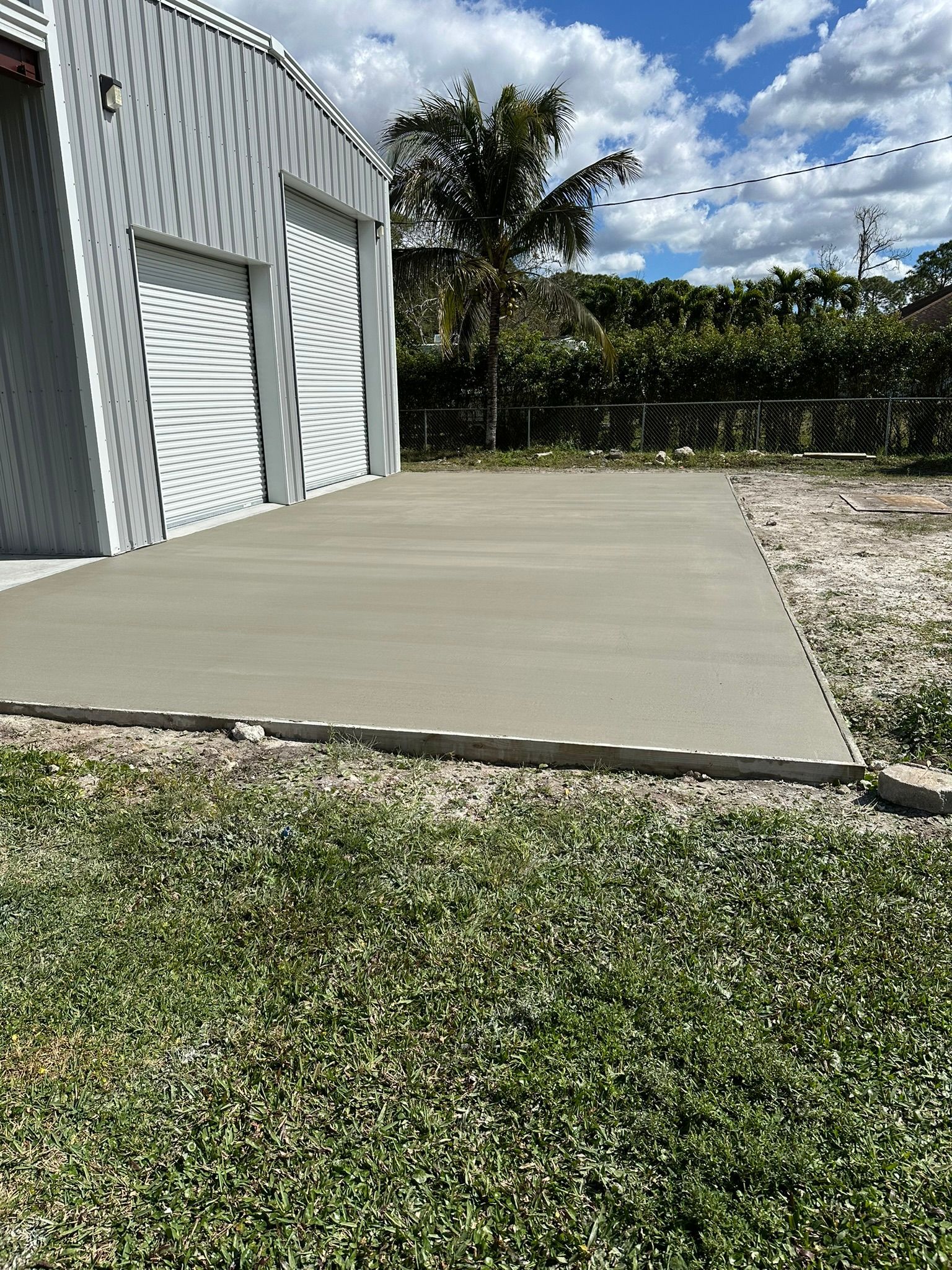 A concrete driveway is being built in front of a garage.