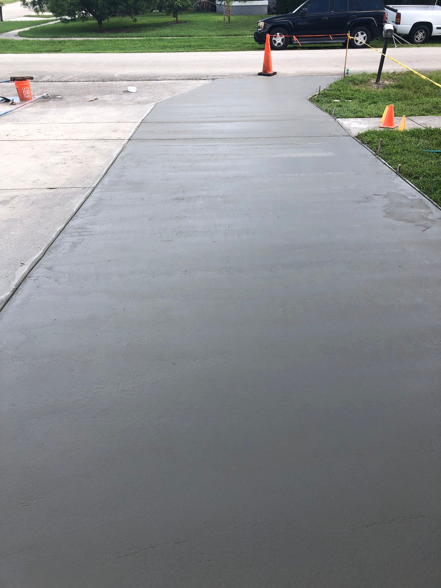 A concrete walkway with a car parked on the side of it.