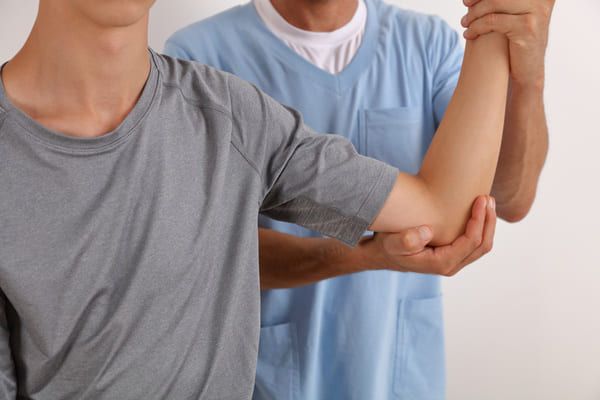 physiotherapist treating a womans elbow