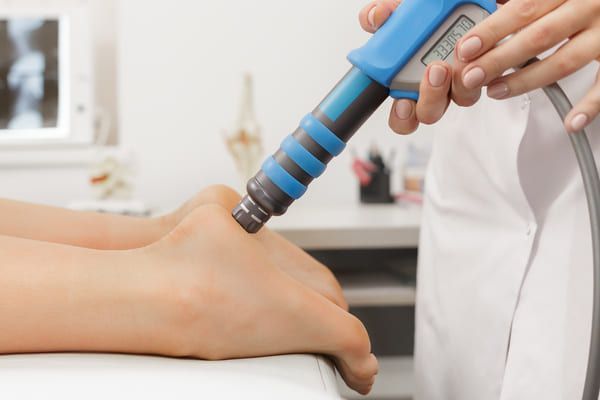 physiotherapist performing shockwave therapy