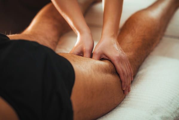 physiotherapist doing a sports massage on the knee